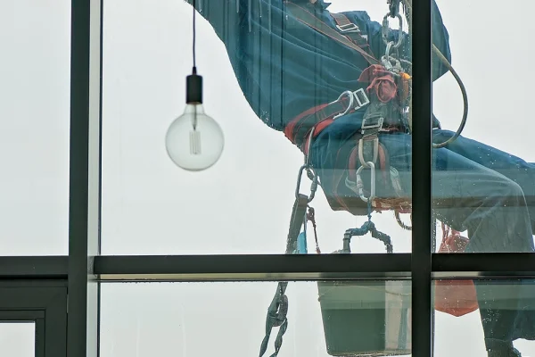 Ein Mitarbeiter bei der professionellen Fassaden-Fensterreinigung für streifenfreie Fenster
